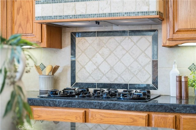 822 Noddy Ct, Arroyo Grande, CA 93420 - kitchen with extractor fan, black gas cooktop, tasteful backsplash, brown cabinets, and dark countertops
