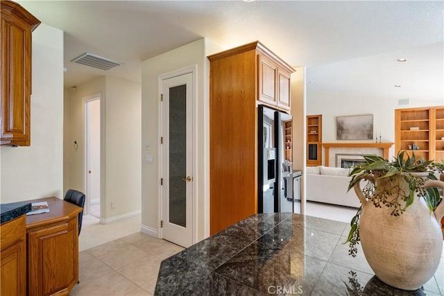 822 Noddy Ct, Arroyo Grande, CA 93420 - kitchen with tile countertops, open floor plan, light tile patterned floors, a glass covered fireplace, and brown cabinetry