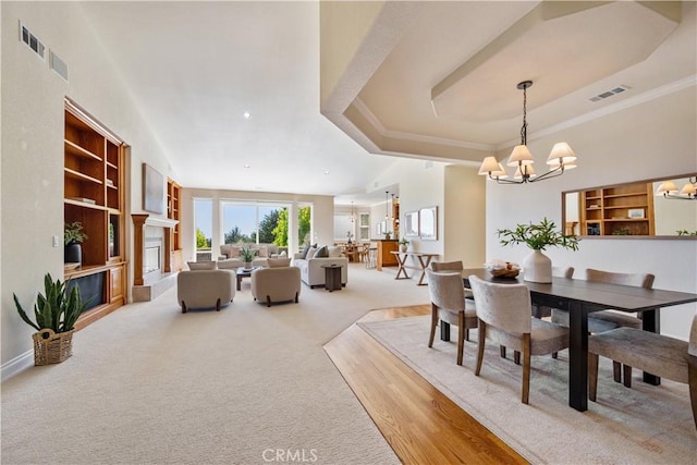822 Noddy Ct, Arroyo Grande, CA 93420 - dining space with a chandelier, carpet, built in shelves, a tray ceiling, and crown molding