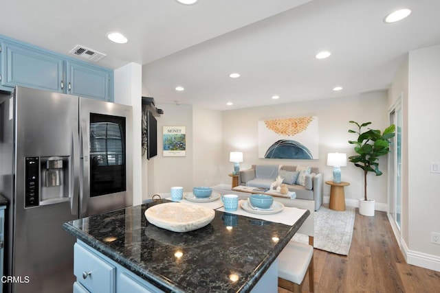 1051 Thomas Ln, Ventura, CA 93003 - kitchen with stainless steel fridge, blue cabinets, dark wood-style flooring, dark stone counters, and open floor plan