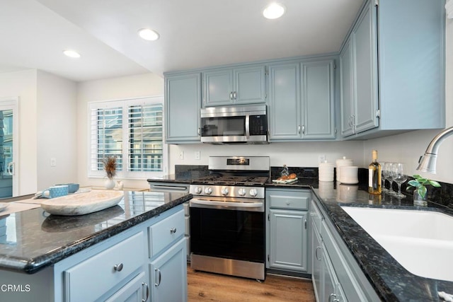 1051 Thomas Ln, Ventura, CA 93003 - kitchen with stainless steel appliances, dark stone countertops, recessed lighting, light wood-style flooring, and a kitchen island