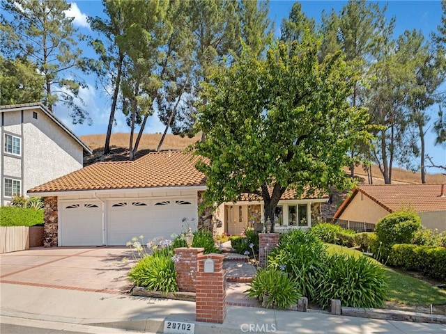 28702 Eagleton St, Agoura Hills, CA 91301 - view of front of home with an attached garage, driveway, a tile roof, and stone siding