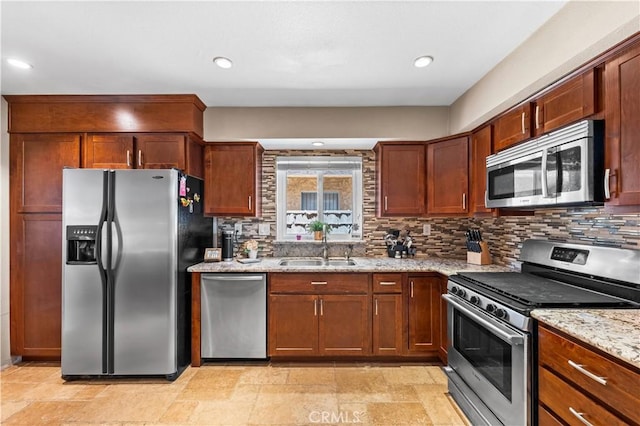 39981 Golfers Ln, Palmdale, CA 93551 - kitchen featuring appliances with stainless steel finishes, light stone countertops, decorative backsplash, recessed lighting, and light stone finish floors