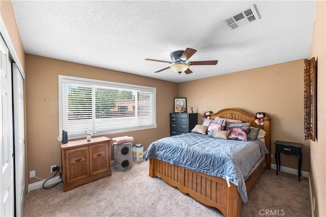 39981 Golfers Ln, Palmdale, CA 93551 - bedroom featuring light carpet, a closet, a textured ceiling, and a ceiling fan