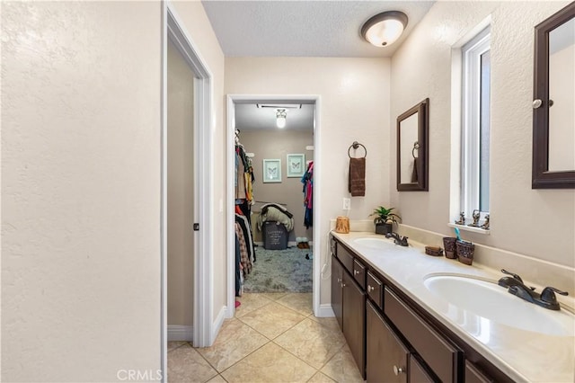39981 Golfers Ln, Palmdale, CA 93551 - full bath with double vanity, tile patterned flooring, a spacious closet, a textured wall, and a textured ceiling