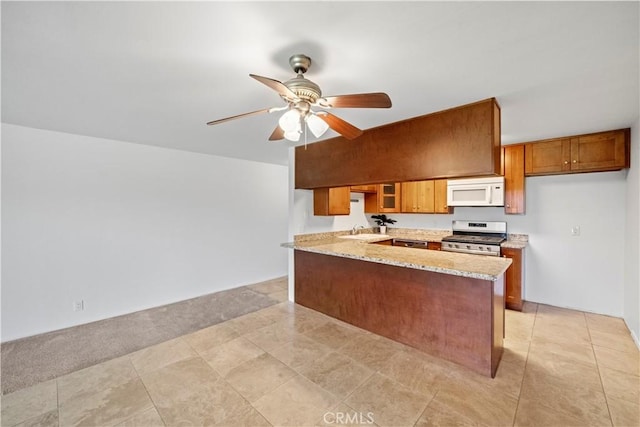 2501 S El Camino Real, San Clemente, CA 92672 - kitchen with stove, white microwave, brown cabinetry, a peninsula, and ceiling fan