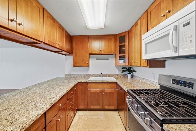 2501 S El Camino Real, San Clemente, CA 92672 - kitchen featuring gas stove, white microwave, brown cabinetry, light tile patterned flooring, and light stone countertops