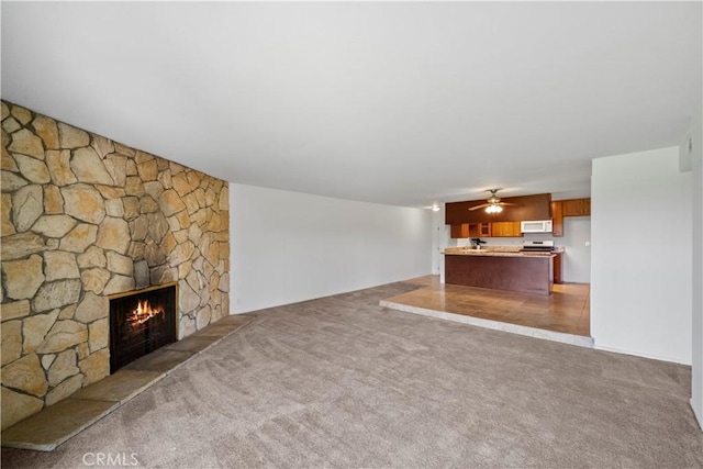 2501 S El Camino Real, San Clemente, CA 92672 - unfurnished living room featuring a stone fireplace, light colored carpet, and ceiling fan