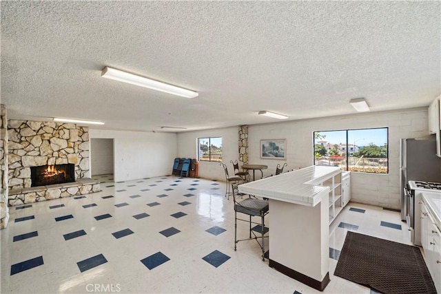 2501 S El Camino Real, San Clemente, CA 92672 - kitchen with tile counters, open floor plan, a textured ceiling, a kitchen bar, and gas range gas stove