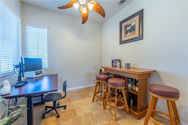 19385 Boulder St, Apple Valley, CA 92308 - home office with a ceiling fan, stone tile flooring, and a dry bar
