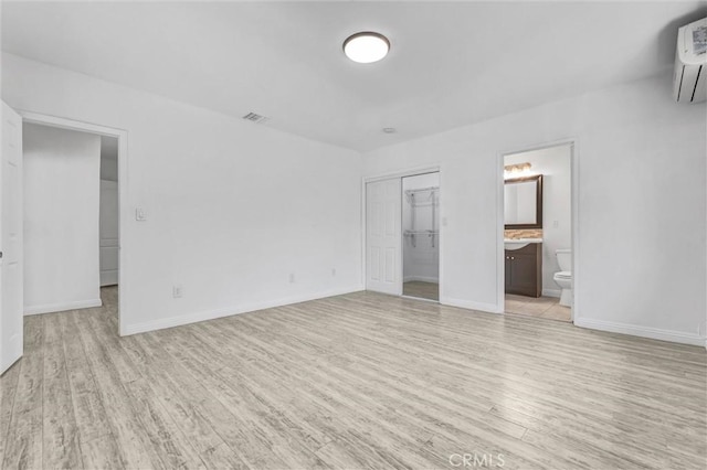 4449 Walnut St, Baldwin Park, CA 91706 - unfurnished bedroom with light wood-type flooring, a wall mounted air conditioner, and ensuite bath