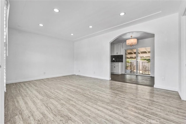 4449 Walnut St, Baldwin Park, CA 91706 - empty room featuring arched walkways, wood finished floors, recessed lighting, and a chandelier
