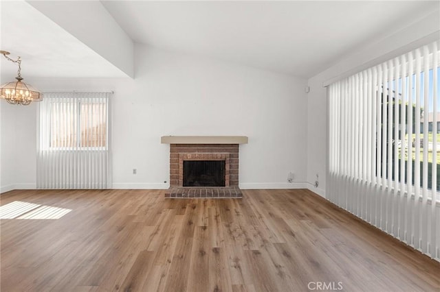 6355 Ortega St, Chino, CA 91710 - unfurnished living room with lofted ceiling, a chandelier, wood finished floors, and a brick fireplace