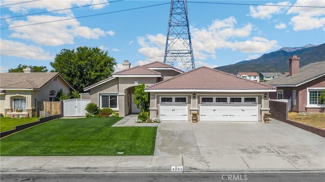 4082 N Flame Tree Ave, Rialto, CA 92377 - ranch-style home featuring stucco siding, driveway, an attached garage, and a mountain view