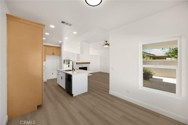 4082 N Flame Tree Ave, Rialto, CA 92377 - kitchen with open floor plan, black dishwasher, light wood-style flooring, a ceiling fan, and light countertops
