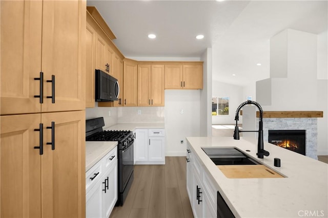 4082 N Flame Tree Ave, Rialto, CA 92377 - kitchen with black appliances, light wood-style flooring, a fireplace, light brown cabinets, and recessed lighting