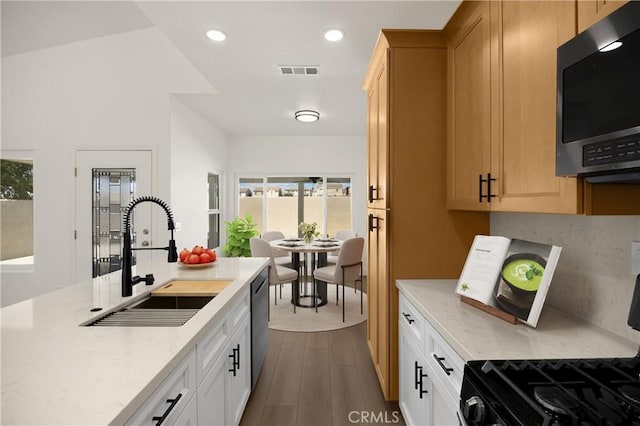 4082 N Flame Tree Ave, Rialto, CA 92377 - kitchen featuring stainless steel dishwasher, plenty of natural light, gas range oven, dark wood finished floors, and recessed lighting