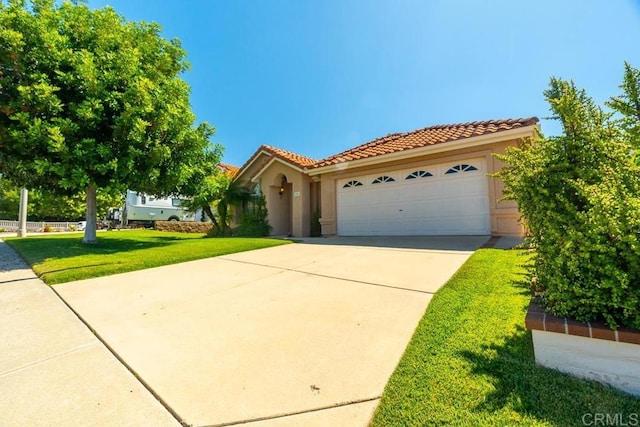 426 Debra An Dr, Fallbrook, CA 92028 - mediterranean / spanish-style house with a tile roof, a front yard, a garage, driveway, and stucco siding
