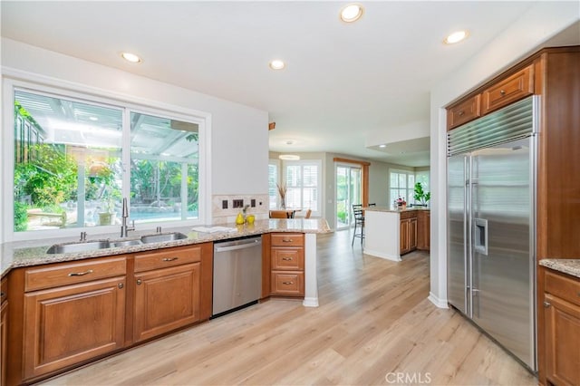 27860 Mount Shasta Way, Yorba Linda, CA 92887 - kitchen featuring appliances with stainless steel finishes, brown cabinets, light wood-style flooring, light stone countertops, and recessed lighting