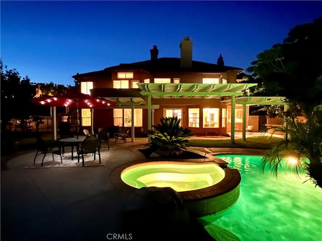 27860 Mount Shasta Way, Yorba Linda, CA 92887 - back of house at night with a pergola, a chimney, a patio area, and a pool with connected hot tub