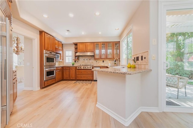 27860 Mount Shasta Way, Yorba Linda, CA 92887 - kitchen with appliances with stainless steel finishes, brown cabinets, a peninsula, light wood-type flooring, and recessed lighting