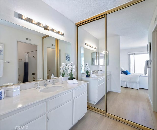 3610 Vista Glen Cir, Yorba Linda, CA 92886 - full bathroom featuring two vanities, wood finished floors, ensuite bathroom, a shower, and a textured ceiling