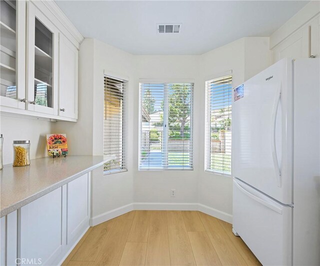 3610 Vista Glen Cir, Yorba Linda, CA 92886 - kitchen with freestanding refrigerator, light wood-type flooring, white cabinetry, light countertops, and glass insert cabinets