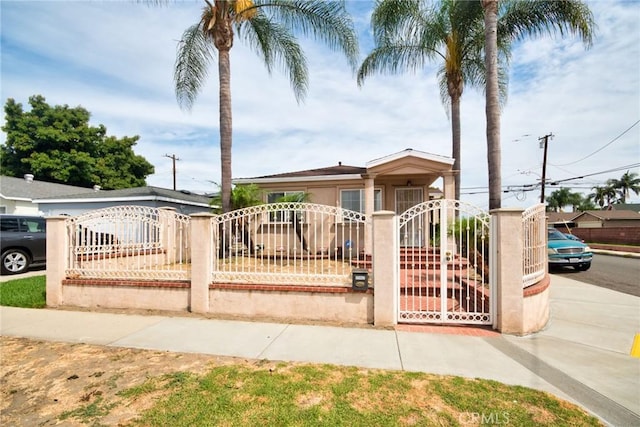11457 Maza St, Norwalk, CA 90650 - view of front of home with a fenced front yard, a gate, and stucco siding