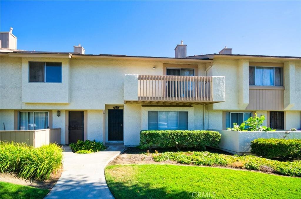 11360 166th St Unit 10, Cerritos, CA 90703 - view of front of home with a balcony, a chimney, and stucco siding