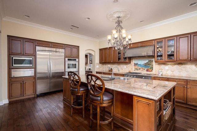 6767 Malachite Pl, Carlsbad, CA 92009 - kitchen featuring built in appliances, extractor fan, a warming drawer, light stone counters, and arched walkways