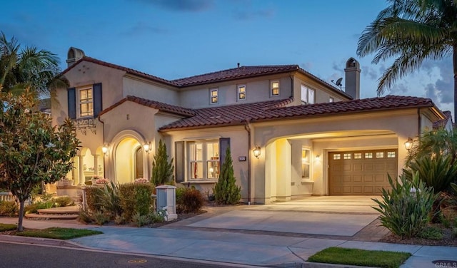 6767 Malachite Pl, Carlsbad, CA 92009 - mediterranean / spanish-style home featuring concrete driveway, a garage, stucco siding, and a tile roof