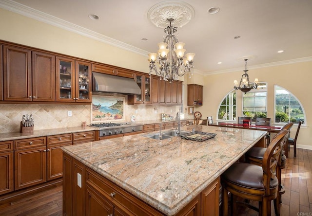 6767 Malachite Pl, Carlsbad, CA 92009 - kitchen with ventilation hood, a chandelier, dark wood-type flooring, a kitchen breakfast bar, and light stone countertops