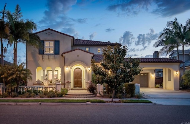 6767 Malachite Pl, Carlsbad, CA 92009 - mediterranean / spanish-style house featuring concrete driveway, a garage, stucco siding, and a tile roof