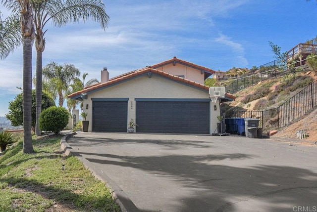 2044 Eula Ln, El Cajon, CA 92019 - view of home's exterior with stucco siding, driveway, a garage, a chimney, and a tile roof