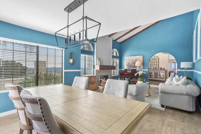 2044 Eula Ln, El Cajon, CA 92019 - dining space featuring wood finished floors, a fireplace, arched walkways, a chandelier, and high vaulted ceiling