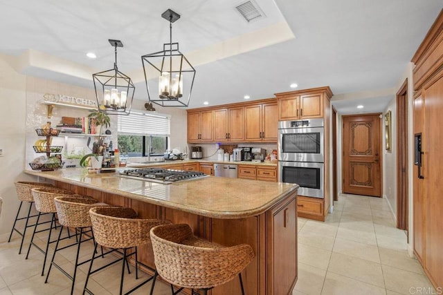 2044 Eula Ln, El Cajon, CA 92019 - kitchen with stainless steel appliances, a peninsula, light tile patterned flooring, a kitchen bar, and brown cabinetry