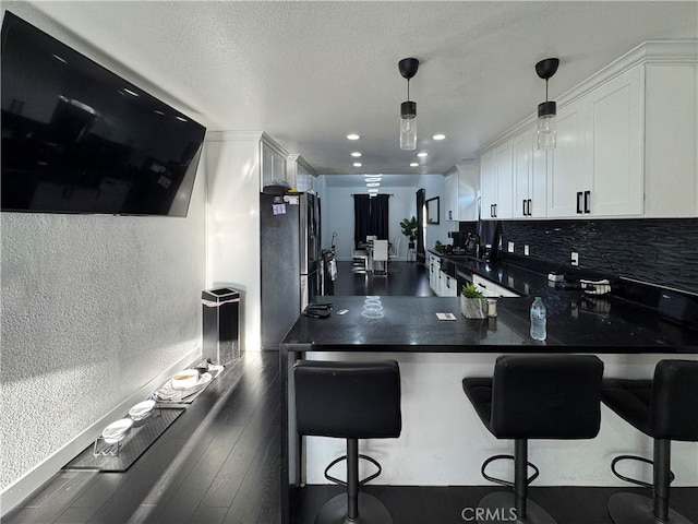 9135 Cord Ave, Downey, CA 90240 - kitchen featuring a textured wall, white cabinets, dark countertops, dark wood finished floors, and stainless steel refrigerator with ice dispenser
