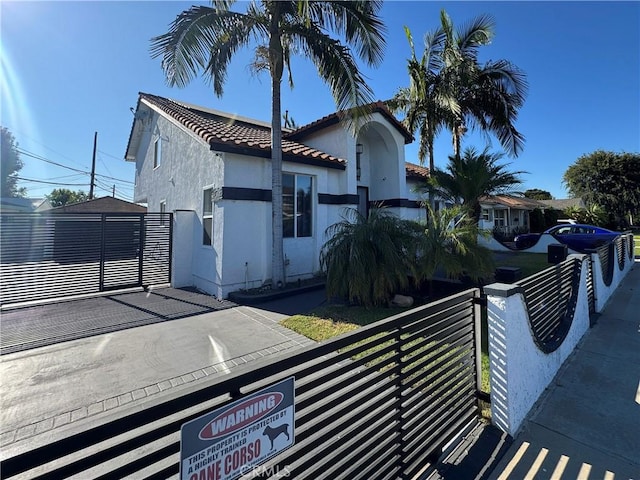 9135 Cord Ave, Downey, CA 90240 - mediterranean / spanish home featuring stucco siding, a tiled roof, and a gate