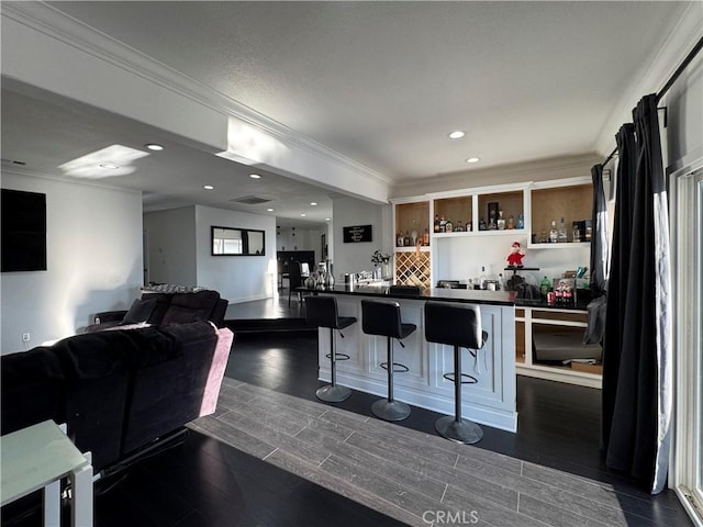 9135 Cord Ave, Downey, CA 90240 - kitchen featuring dark countertops, a breakfast bar area, ornamental molding, dark wood-type flooring, and recessed lighting