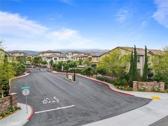31268 Via Nubes, Temecula, CA 92592 - view of asphalt street featuring traffic signs, a residential view, sidewalks, and curbs
