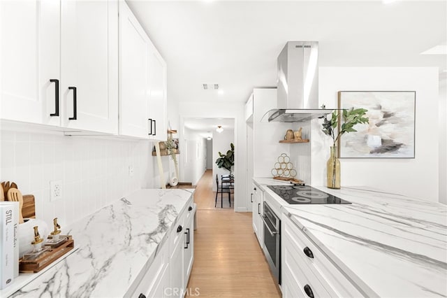 8252 Graves Ave, Rosemead, CA 91770 - kitchen featuring island exhaust hood, black electric cooktop, light wood-style floors, white cabinets, and decorative backsplash