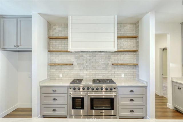 25904 Bear Valley Rd, Tehachapi, CA 93561 - kitchen with open shelves, double oven range, extractor fan, backsplash, and wood finished floors
