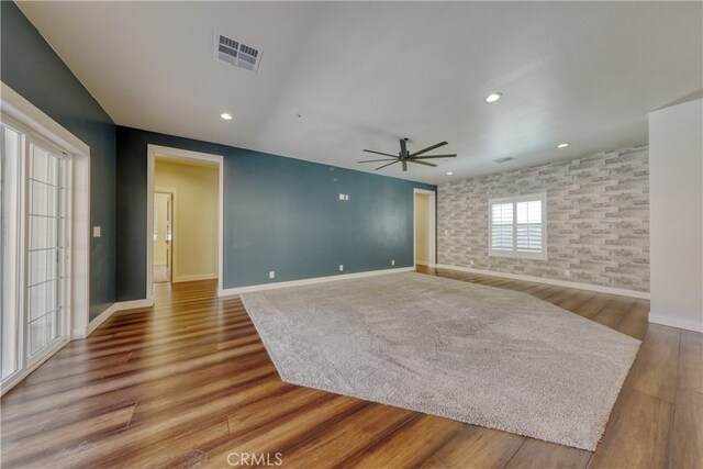 25904 Bear Valley Rd, Tehachapi, CA 93561 - unfurnished living room featuring ceiling fan, wood finished floors, an accent wall, and recessed lighting