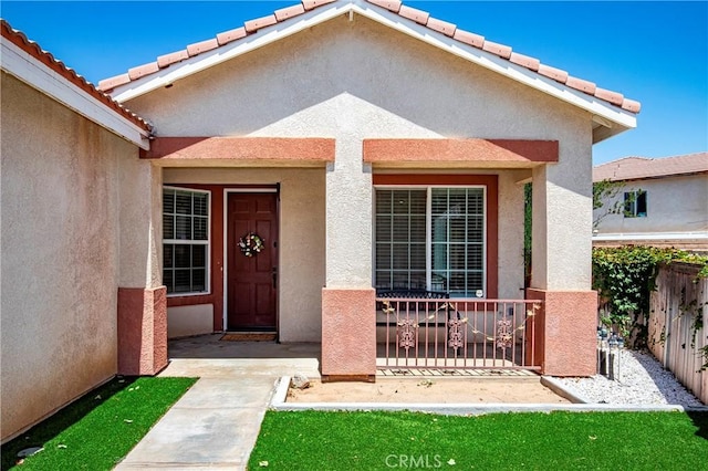 39423 Rowan Ct, Palmdale, CA 93551 - view of exterior entry featuring stucco siding, a porch, and a tiled roof