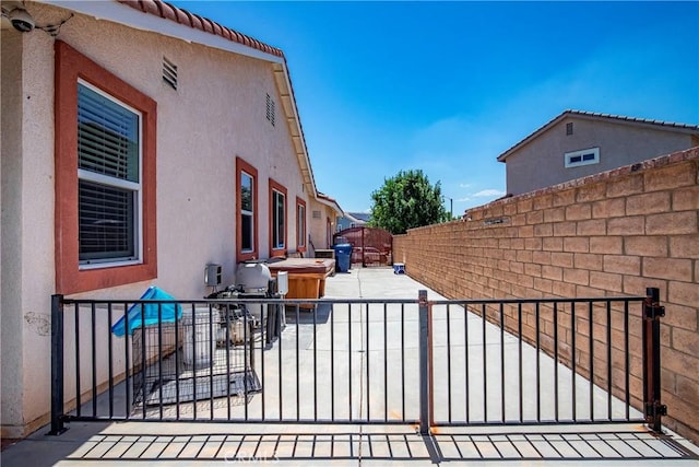 39423 Rowan Ct, Palmdale, CA 93551 - view of side of home featuring a patio, stucco siding, a gate, and a security system