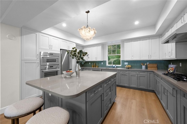 600 Baldwin Ct, Sierra Madre, CA 91024 - kitchen featuring stainless steel appliances, gray cabinetry, a breakfast bar area, light wood finished floors, and recessed lighting