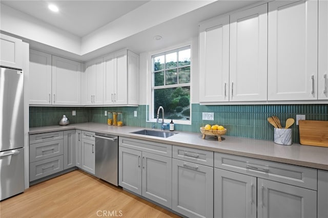 600 Baldwin Ct, Sierra Madre, CA 91024 - kitchen featuring stainless steel appliances, light countertops, gray cabinets, light wood finished floors, and decorative backsplash