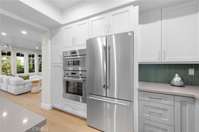 600 Baldwin Ct, Sierra Madre, CA 91024 - kitchen featuring appliances with stainless steel finishes, light wood finished floors, tasteful backsplash, light countertops, and recessed lighting