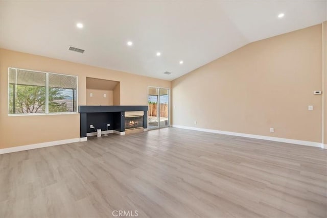 66101 14th St, Desert Hot Springs, CA 92240 - unfurnished living room with healthy amount of natural light, light wood-type flooring, a multi sided fireplace, lofted ceiling, and recessed lighting