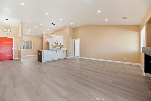 66101 14th St, Desert Hot Springs, CA 92240 - unfurnished living room with lofted ceiling, light wood finished floors, a chandelier, and recessed lighting